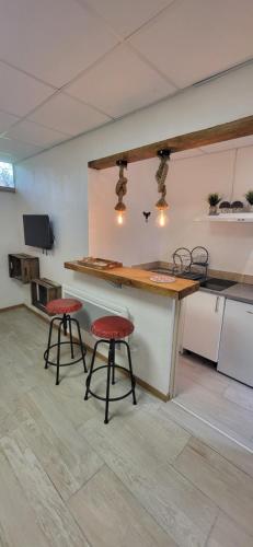 - une cuisine avec deux tabourets et un comptoir dans une pièce dans l'établissement Marciac cœur de jazz, à Marciac