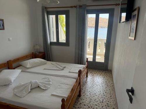 two twin beds in a room with a window at Akti Rooms And Studios in Livadion
