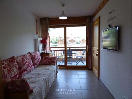 d'un salon avec un canapé et un balcon. dans l'établissement Joli T2 pour 6 pers, balcon sud, face aux pistes, proche commerces, Le Grand-Bornand - FR-1-458-185, au Grand-Bornand