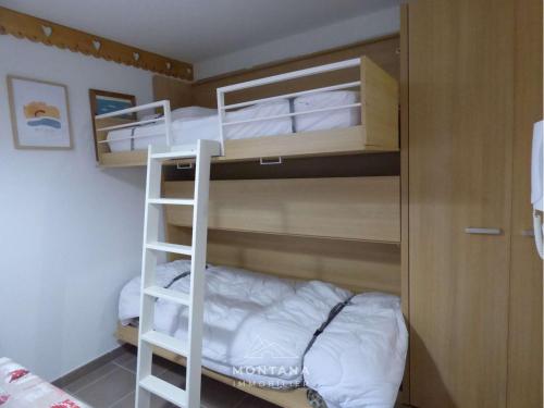 - une chambre avec des lits superposés et un lit dans l'établissement Joli T2 pour 6 pers, balcon sud, face aux pistes, proche commerces, Le Grand-Bornand - FR-1-458-185, au Grand-Bornand