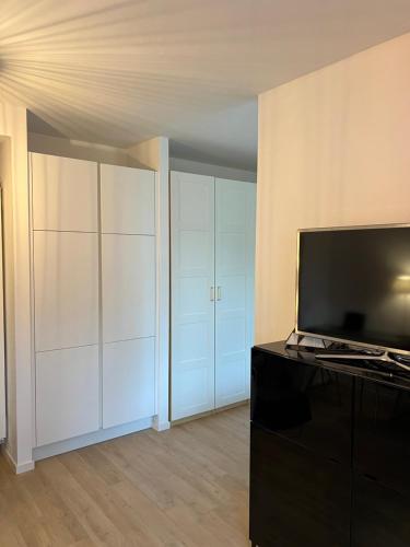 a living room with white cabinets and a flat screen tv at Idylle am Berliner Stadtrand in Schönefeld