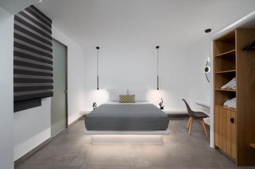a bedroom with a bed and a chair in it at LyMaRou Collection in Megalokhori