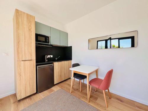 - une petite cuisine avec une petite table et un petit réfrigérateur dans l'établissement Quiberon - Maison T2 rénovée avec jardin clos, proche plages & commerces, parking, WIFI - FR-1-478-285, à Quiberon