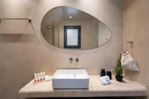a bathroom with a white sink and a mirror at LyMaRou Collection in Megalokhori