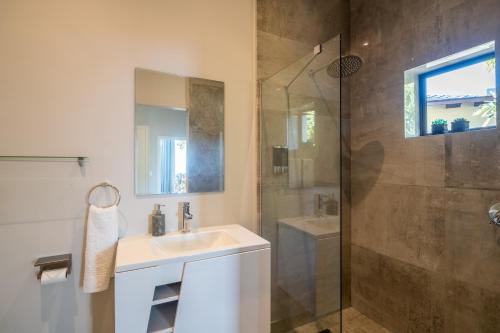 a bathroom with a sink and a shower at Knysna Views - Pezula Seashore - Sea-facing in Knysna