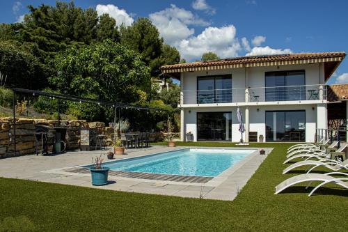 una casa con piscina delante de una casa en Villa Carmen Écrin de Lumière en Provence, en Laouque