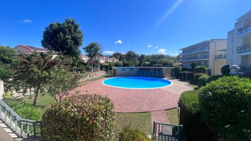 - une piscine dans une cour à côté d'un bâtiment dans l'établissement Appartement 2 chambres dans résidence avec piscine et parking, à La Ciotat