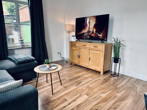 una sala de estar con TV de pantalla plana en una cómoda de madera en FeWo Burgquartier, en Bad Bentheim