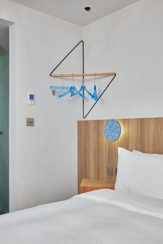 a bedroom with a bed with a hanging rack with blue ties at The Blue by Just Inn in Taipei