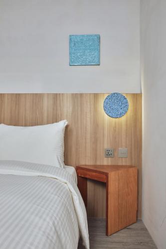 a bedroom with a bed and a wooden night stand at The Blue by Just Inn in Taipei
