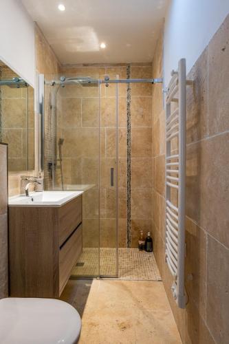 une salle de bain avec une douche, un lavabo et des toilettes dans l'établissement Duplex en plein centre, à Propriano
