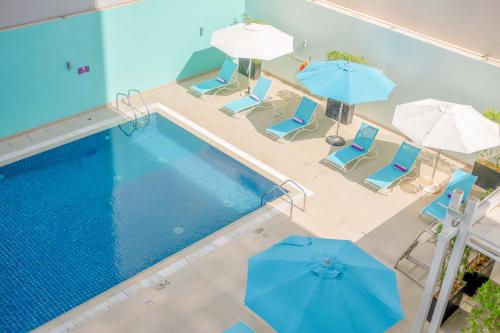 an overhead view of a swimming pool with chairs and umbrellas at Premier Inn Abu Dhabi Capital Centre in Abu Dhabi