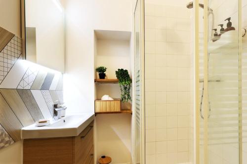 une salle de bain avec un lavabo et une douche dans l'établissement Le Scarlett Nîmois, à Nîmes