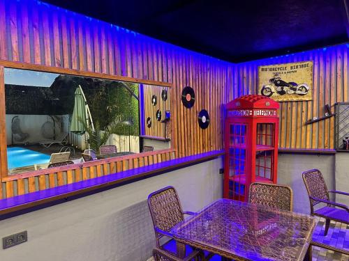 a restaurant with a phone booth and a table and chairs at villa gardens in K'obulet'i
