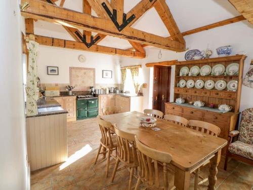 a kitchen with a wooden table and chairs at Beautifully restored cottage nr Knock County Mayo in Kilkelly