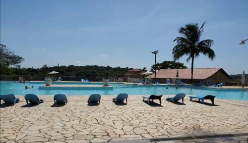 un groupe de chaises devant une piscine dans l'établissement Cantinho da Cake, à Araruama