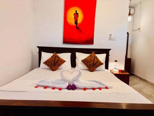 a bed with two towels in the shape of a heart at Bay Street in Beruwala