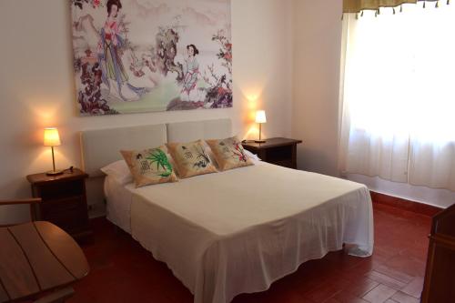 a bedroom with a white bed with two lamps at B&B Casabianca Palinuro in Palinuro
