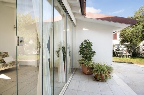 a glass extension of a house with potted plants at Domo Bonaeras in Irgoli
