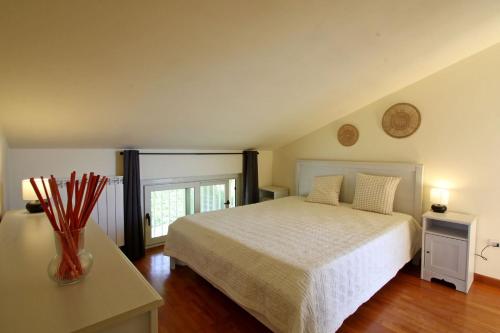 ein Schlafzimmer mit einem Bett und einem Tisch mit einer Vase in der Unterkunft Villa Botrici in Corsanico-Bargecchia