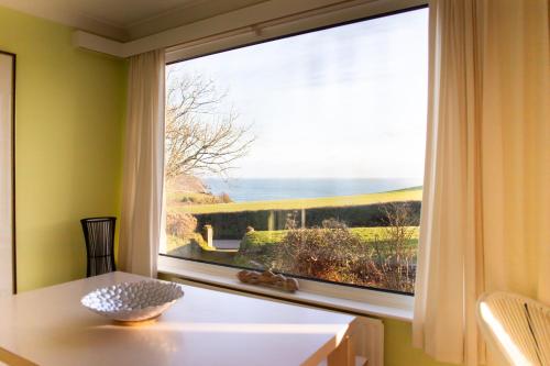 a window in a room with a table and a view at Spectacular Sea View Retreat in Lanteglos