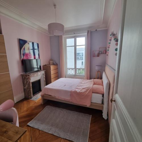 - une chambre rose avec un lit et une cheminée dans l'établissement Haussmannien Appartement 10 min Champs-Élysées, à Neuilly-sur-Seine