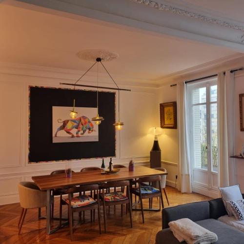 - un salon avec une table à manger et un canapé dans l'établissement Haussmannien Appartement 10 min Champs-Élysées, à Neuilly-sur-Seine