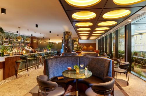 um restaurante com um bar com cadeiras e mesas em The Chancery Hotel em Dublin