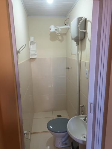 a bathroom with a blue toilet and a sink at Apto 4 ótimo local próximo shopping in Campo Grande