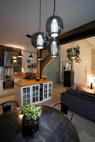 une cuisine et une salle à manger avec une table et quelques lumières dans l'établissement Jolie maison dans la forêt, à Béthemont-la-Forêt