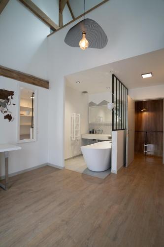 - une grande salle de bains blanche pourvue d'une baignoire dans l'établissement Jolie maison dans la forêt, à Béthemont-la-Forêt