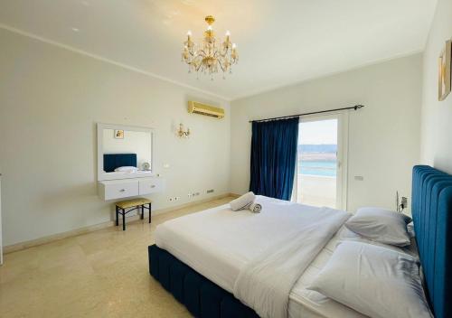 a bedroom with a bed with a window and a chandelier at Unique 6 Bedrooms Villa 38 at White Villas El-Gouna in Hurghada