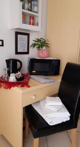 a desk with a microwave and a black chair at Agriturismo I Pipetta in Levanto
