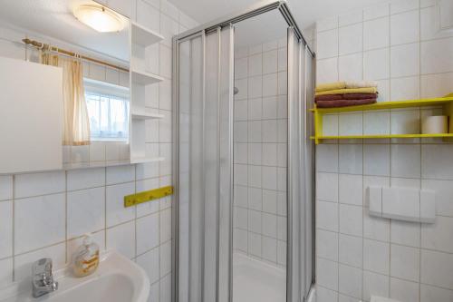 a white bathroom with a shower and a sink at Möve Aba Bungalow 65 in Rerik