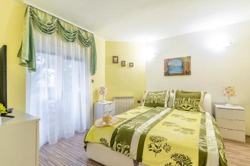 Un dormitorio con una cama amarilla y una ventana en Apartments Villa Rudi, en Bibinje