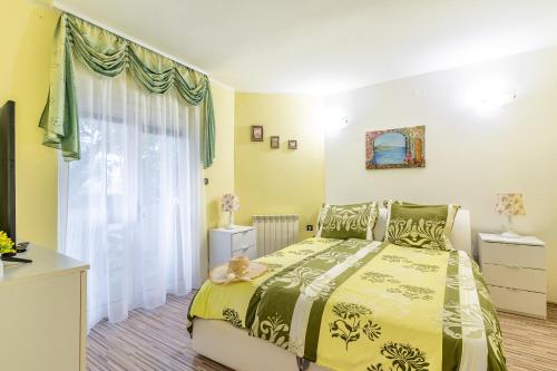a bedroom with a yellow bed and a window at Apartments&Rooms Villa Rudi in Bibinje