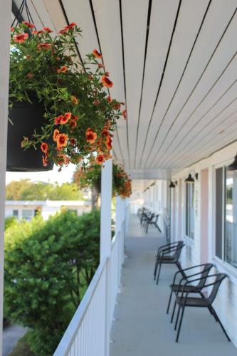 a porch with chairs and flowers on a house at Auberge le Parasol in Saguenay