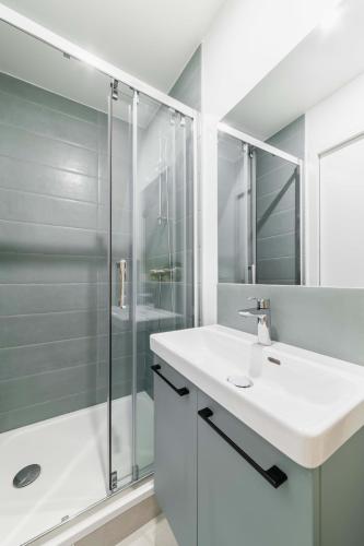 une salle de bain blanche avec un lavabo et une douche dans l'établissement 2 pieces refait a neuf dernier etage - Paris 19 - 4P - FLAT-GUEST, à Paris