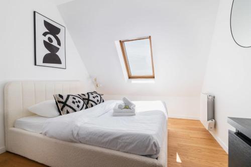 une chambre avec un lit blanc avec un miroir dans l'établissement 2 pieces refait a neuf dernier etage - Paris 19 - 4P - FLAT-GUEST, à Paris