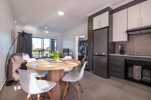 a kitchen with a table and chairs in a room at Ballito Village Luxury Apartments in Ballito