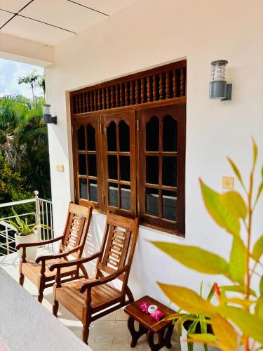 two chairs sitting on the porch of a house at Bay Street in Beruwala