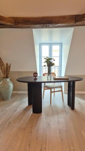 a dining room with a table and a chair at L'Arbre Voyageur in Autun