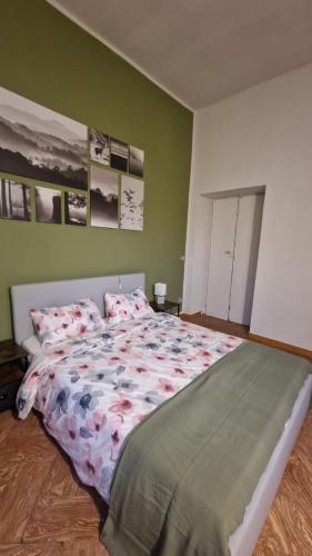 a large bed in a bedroom with green walls at villetta con giardino privato in Cremia