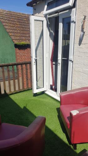 a yard with a red couch and a sliding glass door at All Seasons Guest House in Great Yarmouth