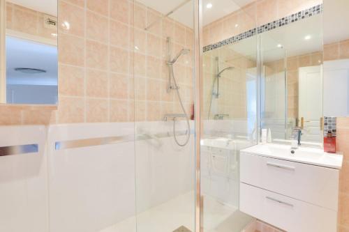 une salle de bain blanche avec une douche et un lavabo dans l'établissement Appartement de luxe 4 pièces Juan Flore, à Antibes