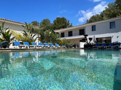 une piscine avec des chaises et un bâtiment dans l'établissement Villa Simon, à Sanary-sur-Mer