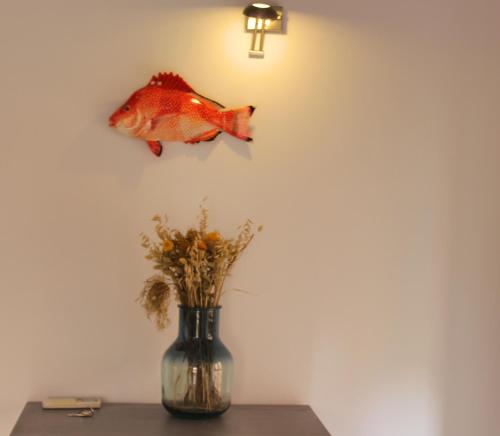 a vase sitting on a table with a fish on the wall at Duplex en el Carmen 1 in Valencia