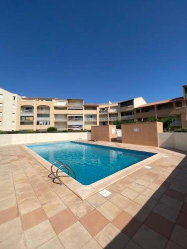 une piscine devant un immeuble dans l'établissement Apt 5 personnes parking - piscine collective - front de mer - Ménage inclus -V0730, à Vias