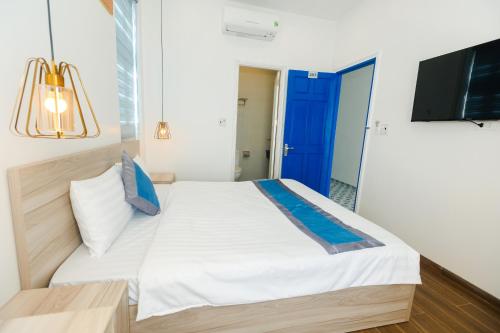 a bedroom with a bed and a flat screen tv at Lee House Villa Tam Thanh in Tam Ky