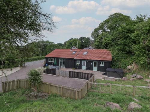 a small black house with a red roof at Bottom Lodge in Chepstow